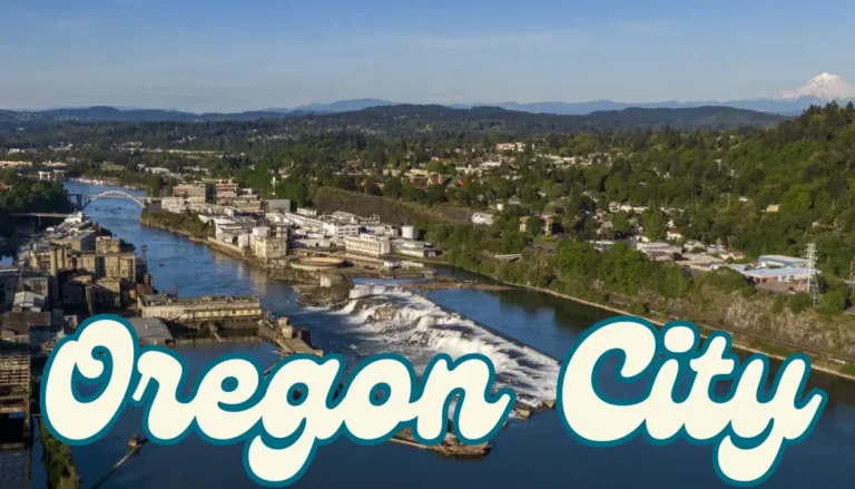 Willamette Falls flowing through Oregon City with lush trees nearby.